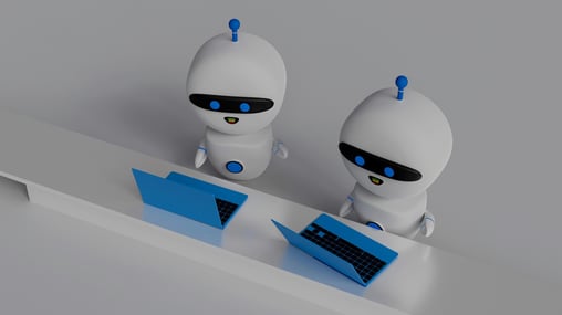 two mini AI robots working on laptops side by side